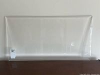 Full view of clear lucite slab leaning against wall