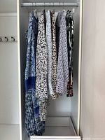 Six patterned garments hanging in closet