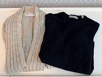 Folded beige cardigan and black sweater