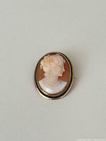 Front view of oval shell cameo brooch pendant