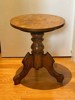 Full view of walnut side table showing round top, turned pedestal, tripod legs