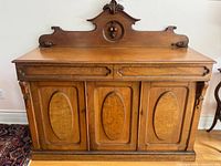Front view showing entire sideboard with carved fruit crest, drawers and doors