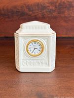 Front view of porcelain desk clock showing dial and embossed design