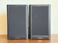 Front view showing both Mission speakers with grilles and logo.