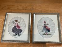 Both framed needlepoint pictures side by side
