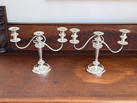 Two Birks Regency Plate 3-arm silver-plated candelabras side by side on tabletop
