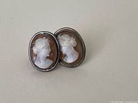 front view of both shell cameo earrings showing carved female profiles and silver-tone bezel