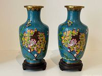 Front view of both cloisonné vases on stands