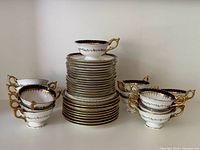 Group shot of stacked plates, tea cups and cream soup bowls