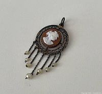 Front view of round filigree cameo pendant with pearl drops