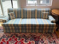 Front view of striped taffeta damask three-seat sofa with two matching cushions