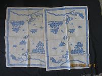 Full view of both matching Willow pattern tea towels laid flat