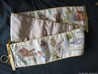 Full length bell pull showing wildlife needlepoint and brass hardware