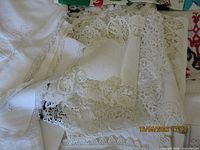 group of lace linens with colourful scarf edge visible
