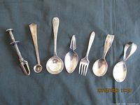 All seven flatware pieces laid out on dark background