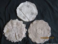 Three stacks of doilies showing linen and crochet varieties