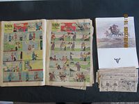 Blondie comic pages opened beside stack of clippings and magazine
