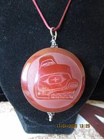 Front view of carved agate pendant on display bust