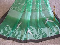Full scarf laid flat showing design, birds, water, black border