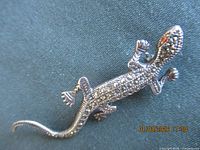 Front view of silver lizard brooch with marcasite stones