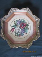 Full view of octagonal gilt frame with petit point floral picture