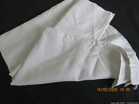 Folded white linen bed sheet showing fabric texture