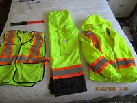 Entire set laid out: safety lamp, waterproof trousers, mesh vest, hooded jacket
