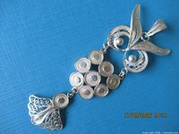 full view of silver owl pendant on blue background