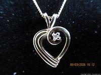 Front view of 10k gold heart pendant showing clear stone and chain