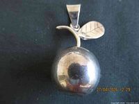 front view of silver-tone apple pendant showing overall form