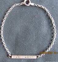 Full view of bracelet laid flat showing chain, bar, and clasp