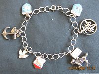 Full view of sterling silver link bracelet with all eight charms visible