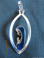Front view of sterling silver pendant showing blue enamel Mother Mary profile within open frame