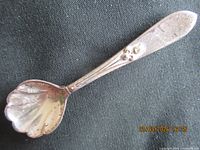 Front view of sterling spoon brooch showing scalloped bowl and floral handle detail