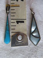 Front view of both pendants beside ruler for scale