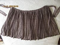 Full view of lace skirt laid flat showing waistband, ties, and gathered fabric