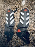 front view of both shin guards showing shell design, ankle guards and Adidas logos