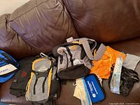 All items laid on brown couch showing backpacks, stuff sack, pouches, hydration bladder