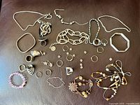 Full lot overview on brown background showing all necklaces, bracelets, rings, bangles and earrings
