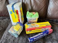 Overall lot showing napkin pack, two foil rolls, microfiber cloth tub, sponge jar