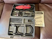 Open case displaying rotary tool, flex shaft, accessories, manual