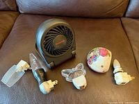 Front view of Honeywell fan and five night lights displayed on brown surface