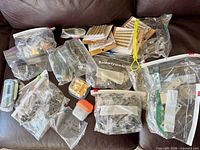 Overview of multiple zip bags and containers filled with mixed hardware items