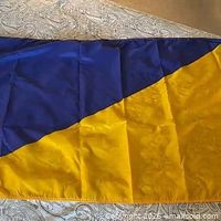 Full view of the blue and yellow diagonal nautical flag laid flat