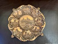 Full view of embossed decorative plate showing Köln am Rhein centre and surrounding landmark reliefs