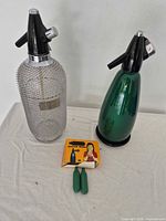 Two soda siphons standing with Natur Soda box and two cartridges