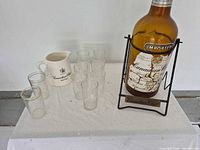 Group shot showing bottle in stand, jug, and glasses