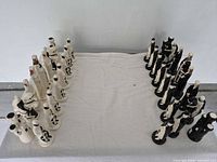 Overhead view of full chess set arrayed on cloth surface
