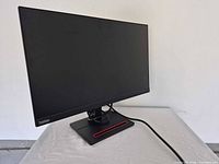 Front angled view of Lenovo ThinkVision monitor on stand with cable attached