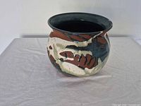 Oblique view of stoneware pot showing multicoloured glaze and form